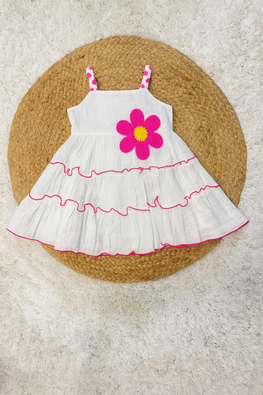 White tiered frock with bold pink flower