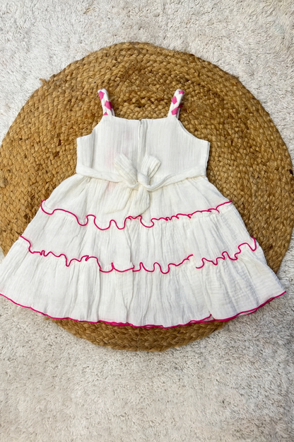 White tiered frock with bold pink flower