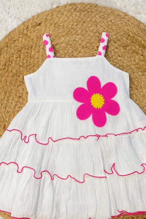 White tiered frock with bold pink flower